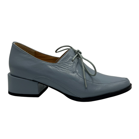 Right facing view of a blue leather derby shoe with leather lining, wrapped block heel and ingle eyelet laces.