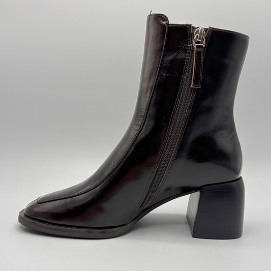 Left facing view of a dark brown short boot with an elastic side panel and a block heel