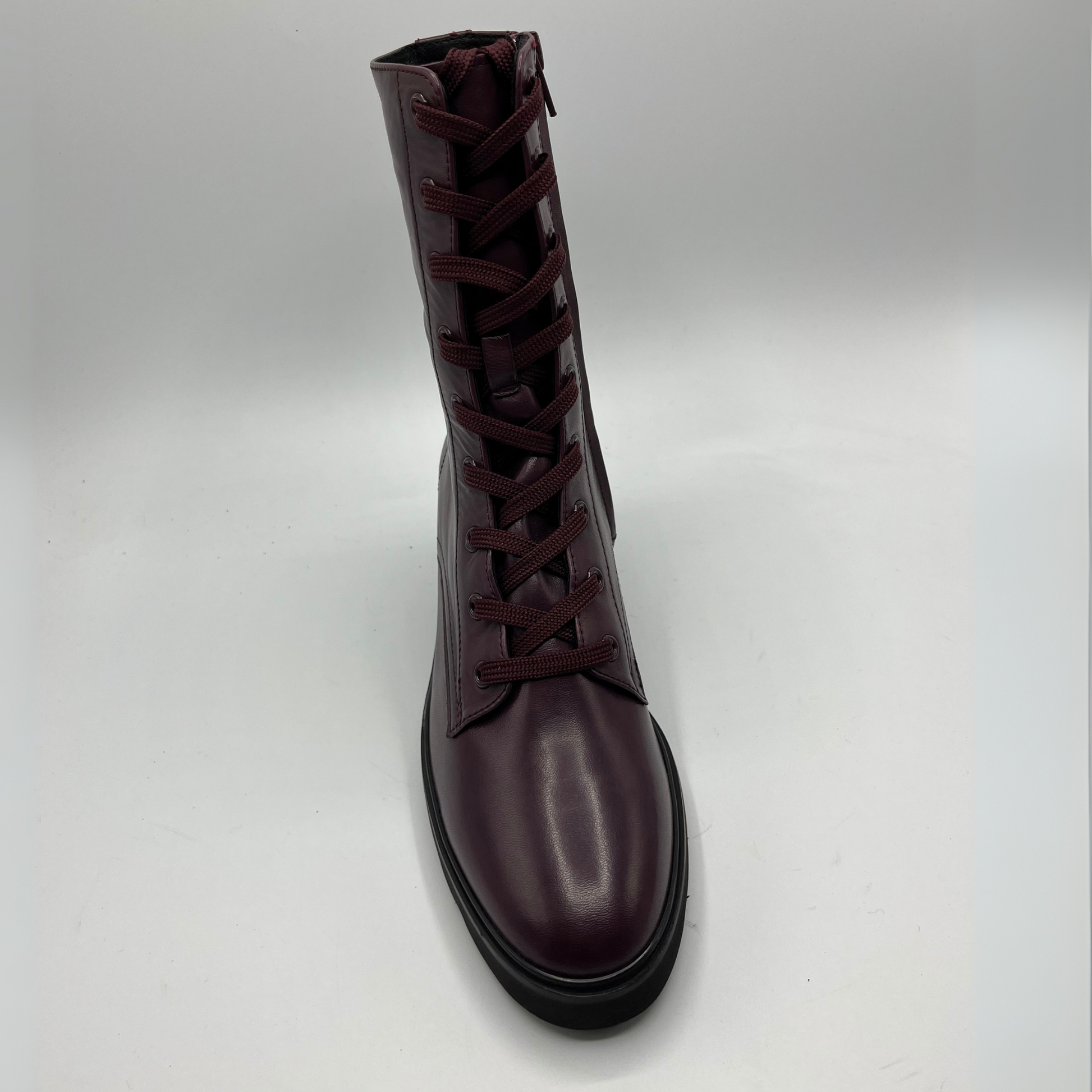 Dark brown leather boot with laces on a light gray background
