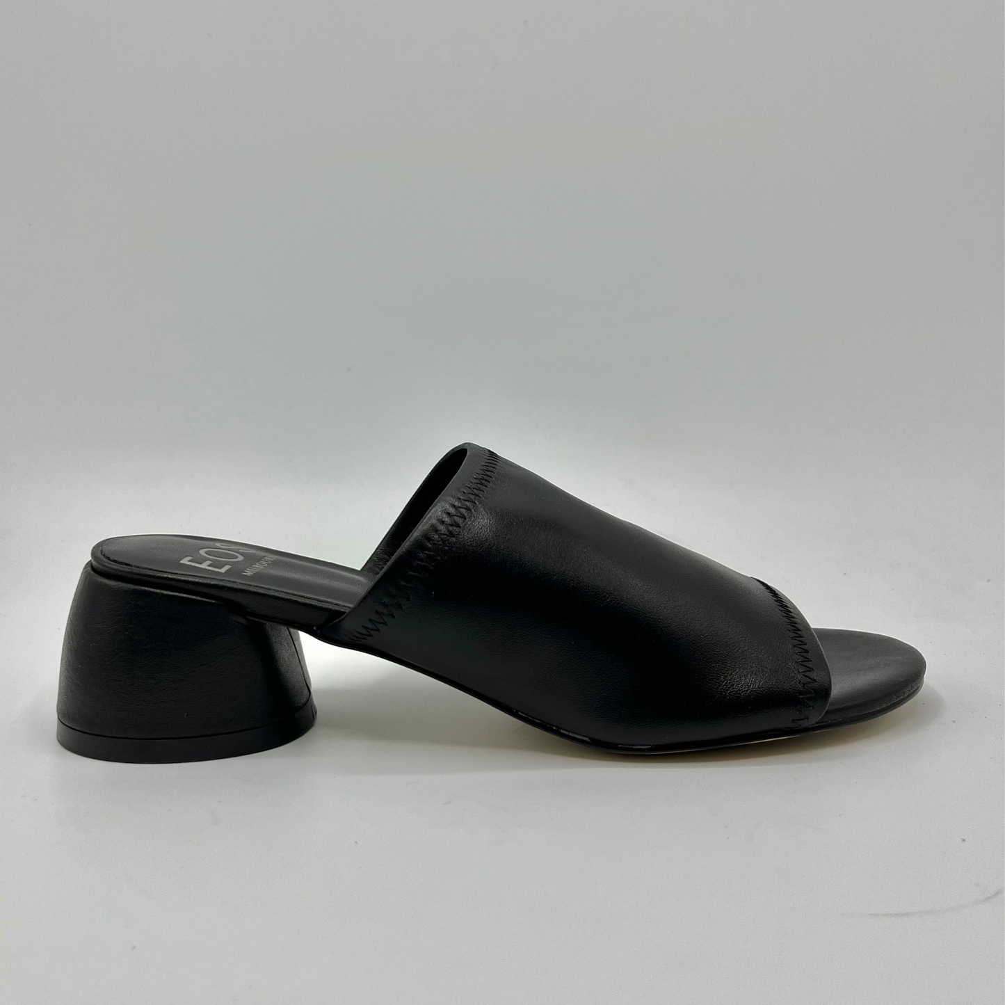Right facing view of a black leather slip on sandal with a chunky rounded heel
