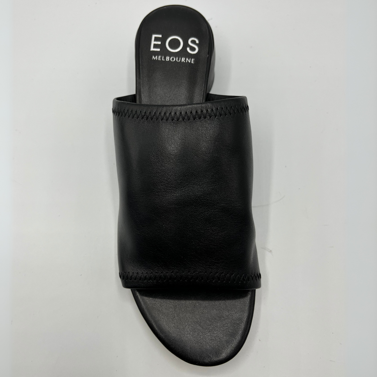 Top view of a black leather slip on sandal with a chunky rounded heel