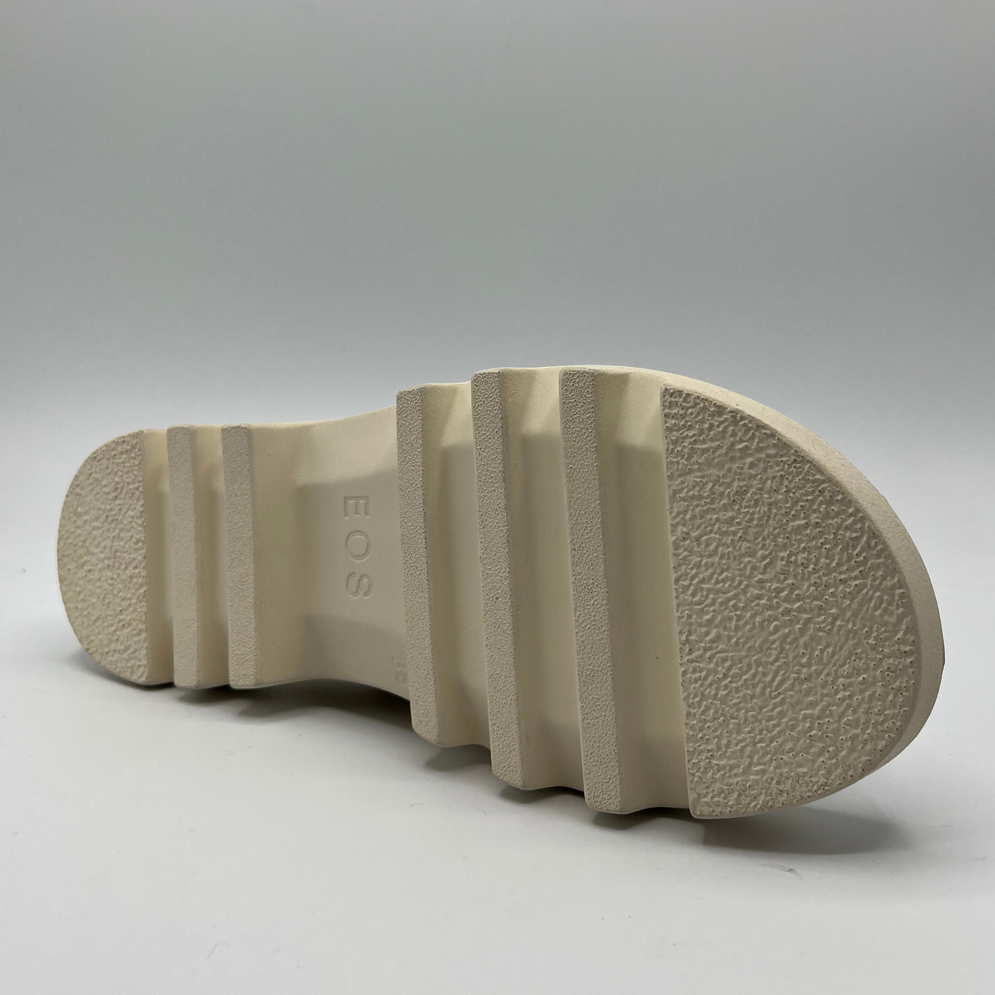 Bottom view of a bone coloured chunky sandal with an adjustable slingback strap and cross over strapped upper.
