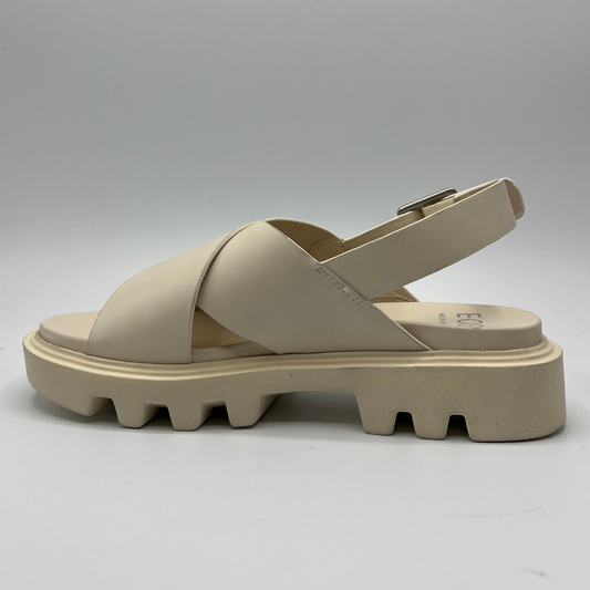 Left facing view of a bone coloured chunky sandal with an adjustable slingback strap and cross over strapped upper.