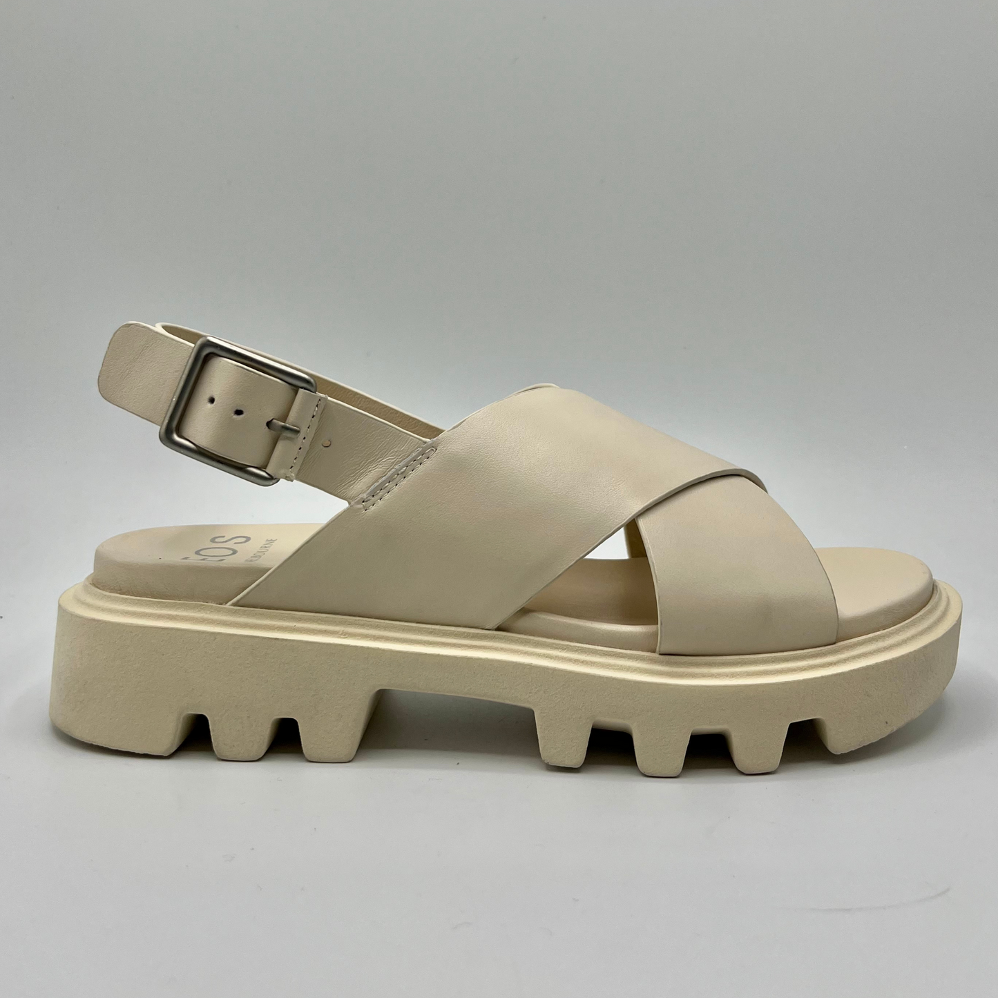 Right facing view of a bone coloured chunky sandal with an adjustable slingback strap and cross over strapped upper.