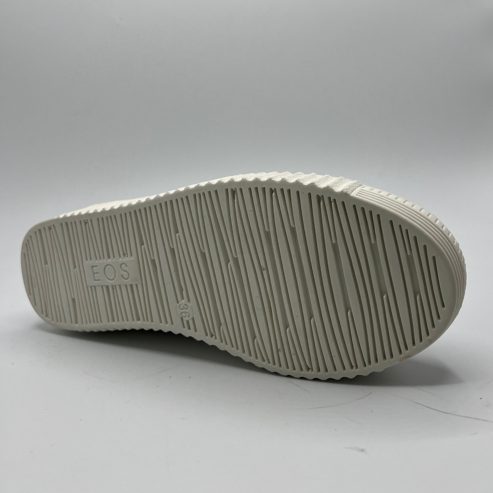 Close-up of a white shoe sole with 'EOS' branding on a light gray background