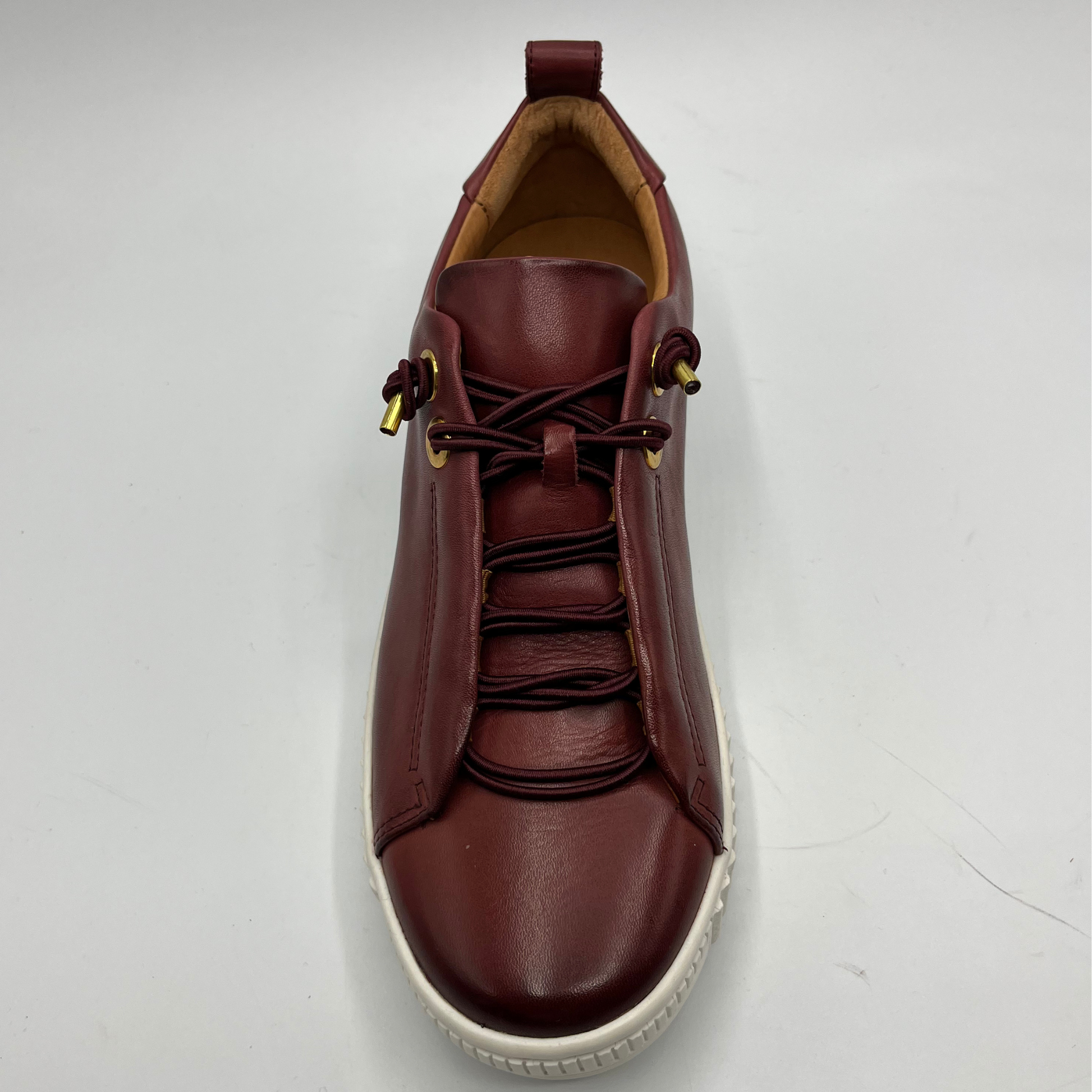 Brown leather sneaker with white sole on a light gray background