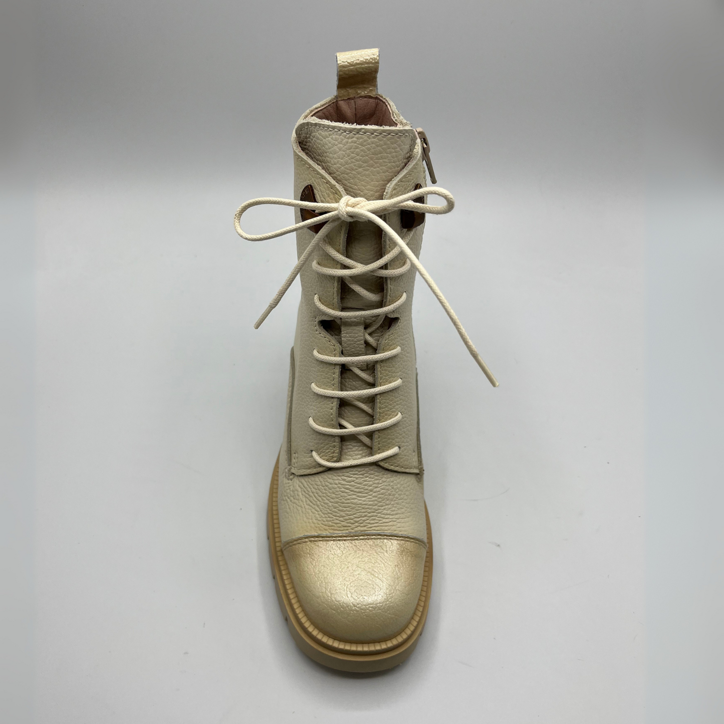 Beige leather boot with laces on a gray background