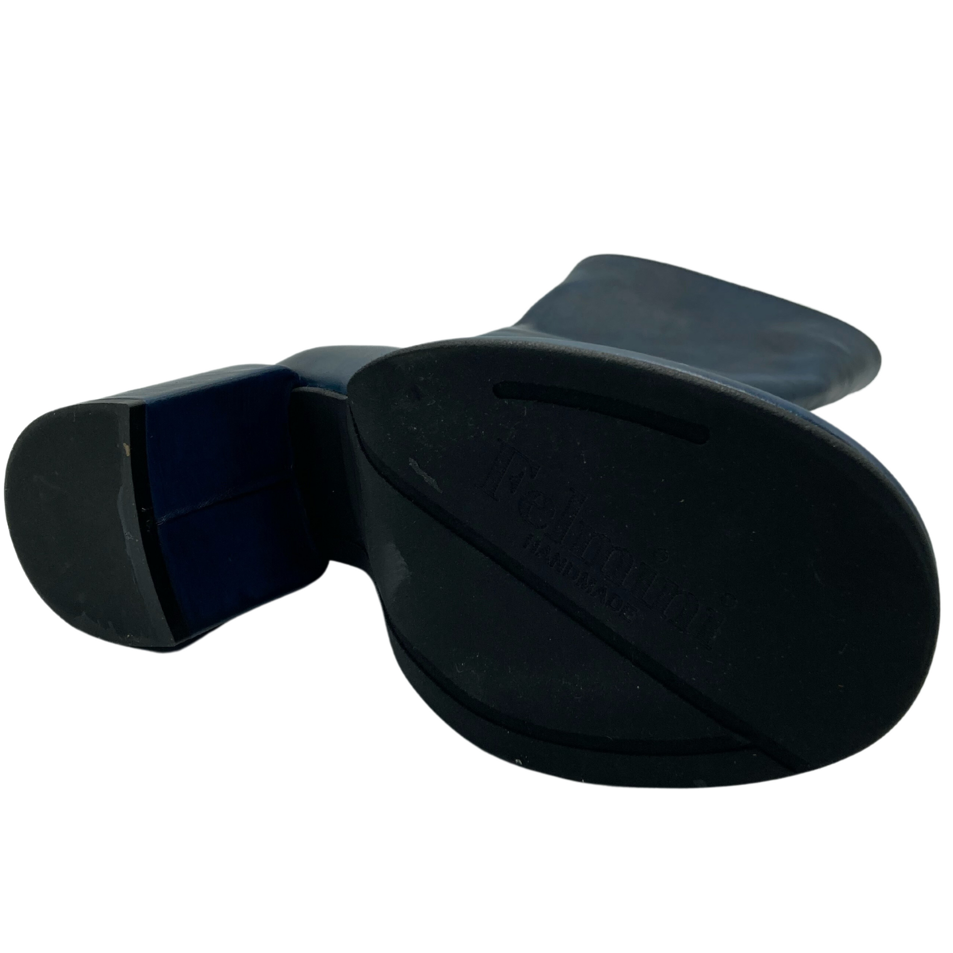 View of the black rubber sole and heel of dark blue leather boot