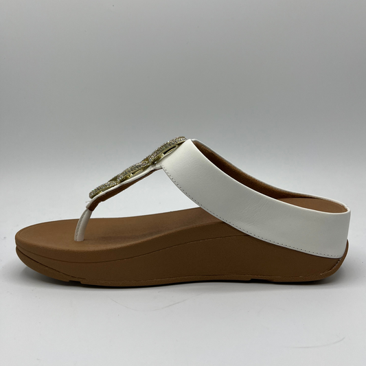 Left facing view of a leather wedge sandal with a white strap and toe post. Featuring a crystal chain detail on the strap.