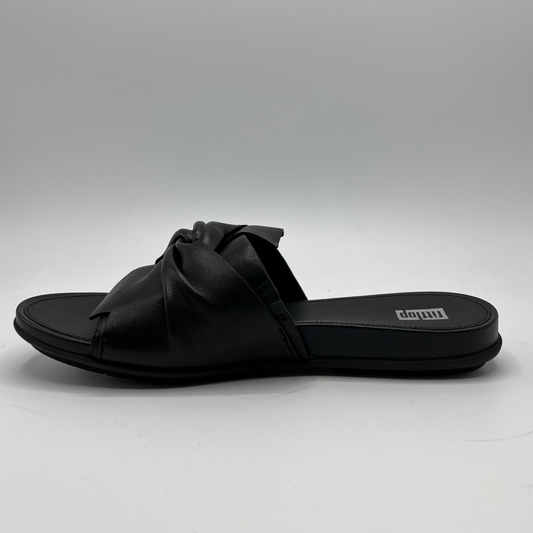 Left facing view of a black leather slip on sandal with a twisted accent on the upper. Contoured, cushioned footbed and rubber outsole.