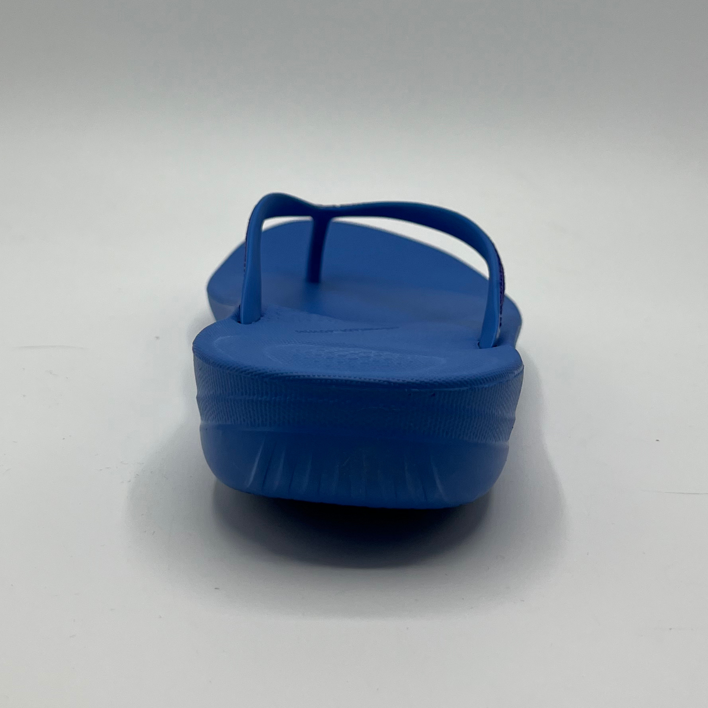 Back view of a cushioned blue slip flop sandal with a sparkly strap and cushioned footbed.