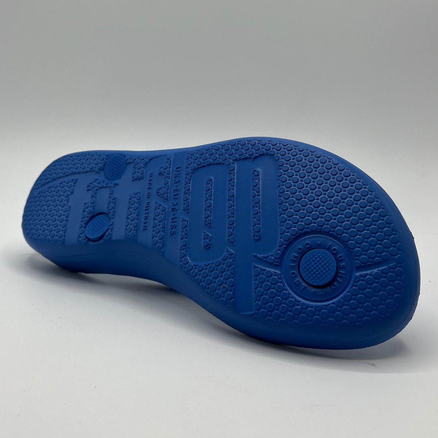 Bottom view of a cushioned blue slip flop sandal with a sparkly strap and cushioned footbed.