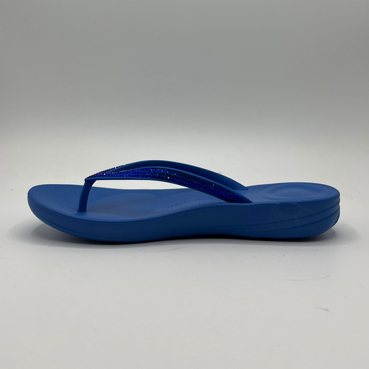 Left facing view of a cushioned blue slip flop sandal with a sparkly strap and cushioned footbed.