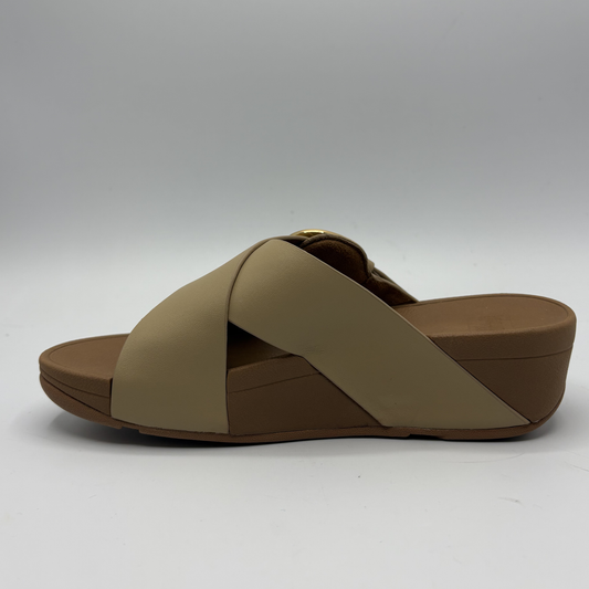 Brown sandal with criss-cross strap design on a white background
