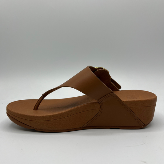 Left facing view of a tan leather slip on sandal with a resin tortoise shell buckle and a toe post.