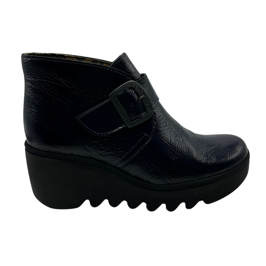 Right facing view navy patent leather wedge ankle boot with buckle strap and black outsole