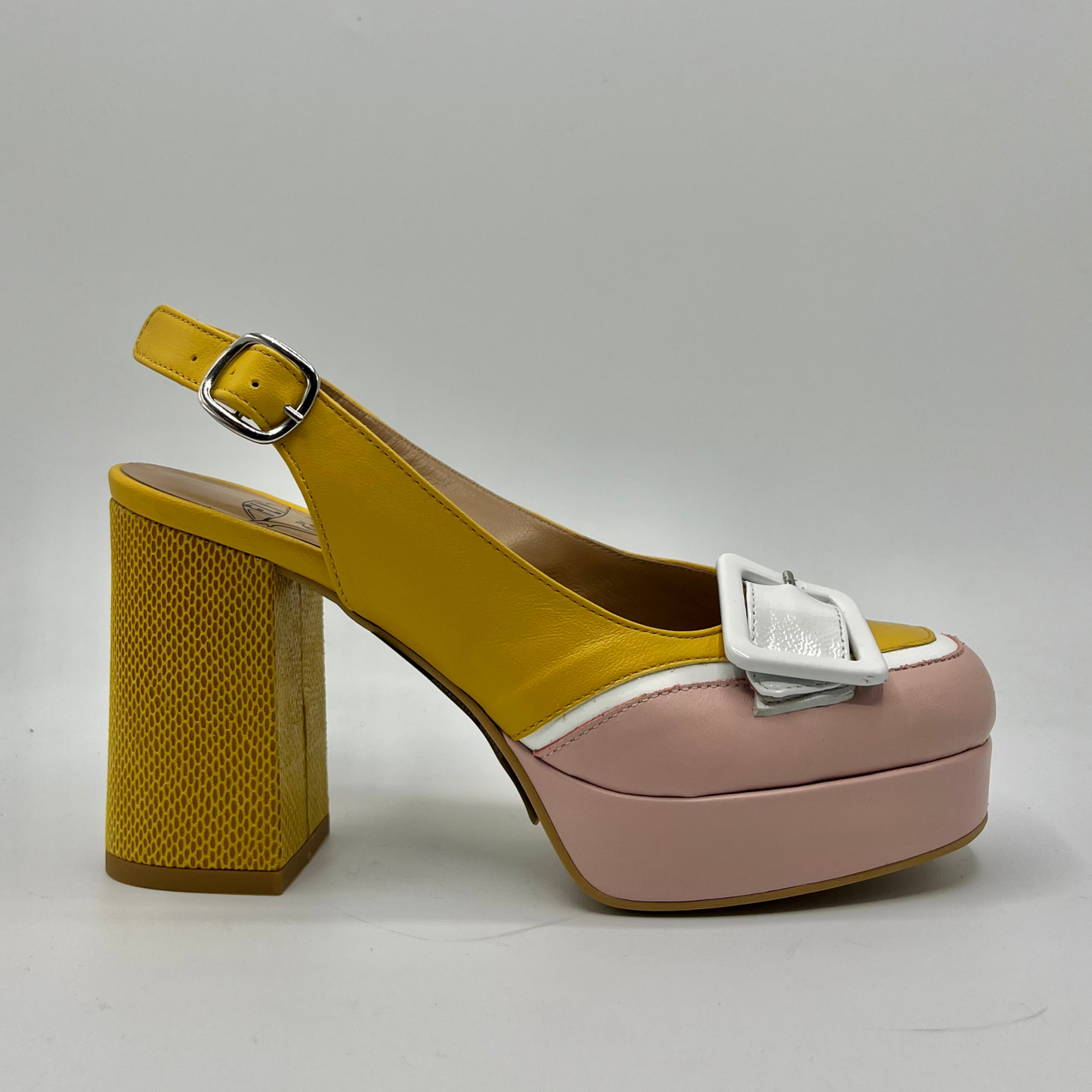Right facing view of a yellow and pink high heeled shoe with a white buckle detail and an adjustable slingback strap.