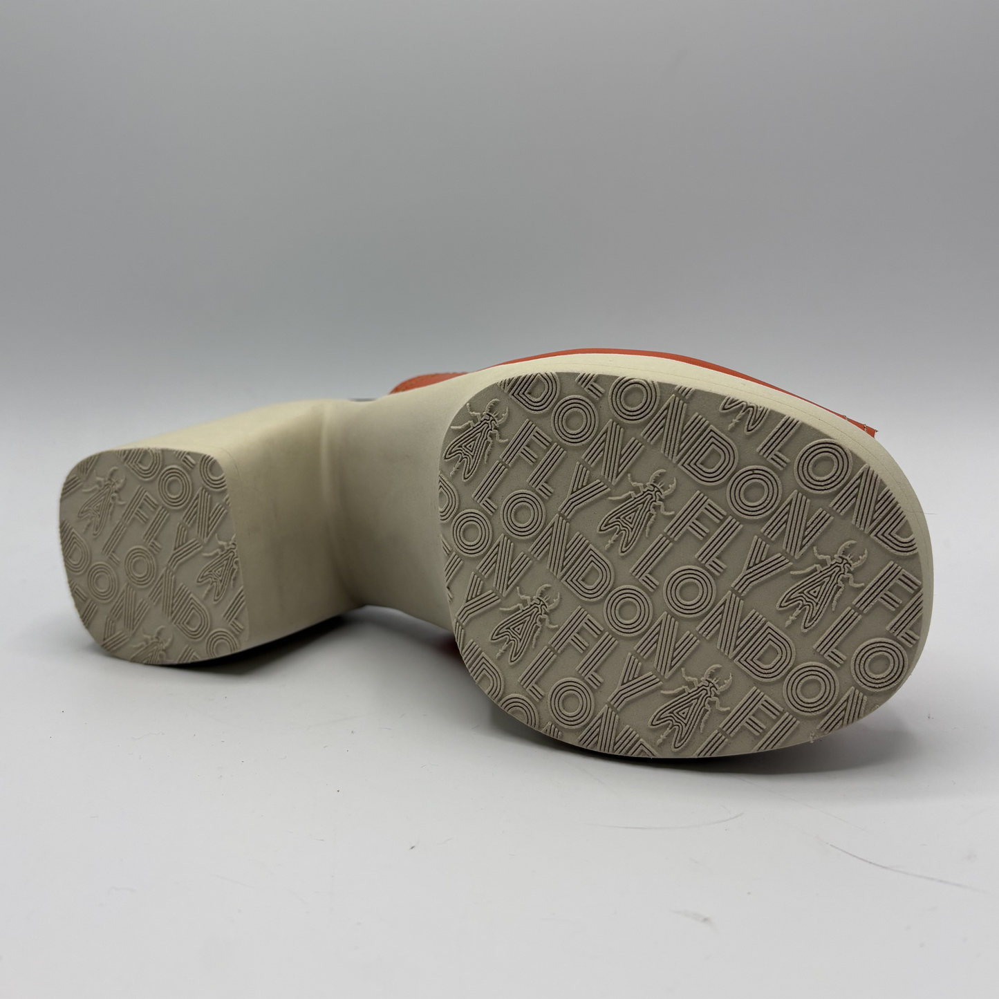 Close-up of a shoe sole with brand logo on a gray background