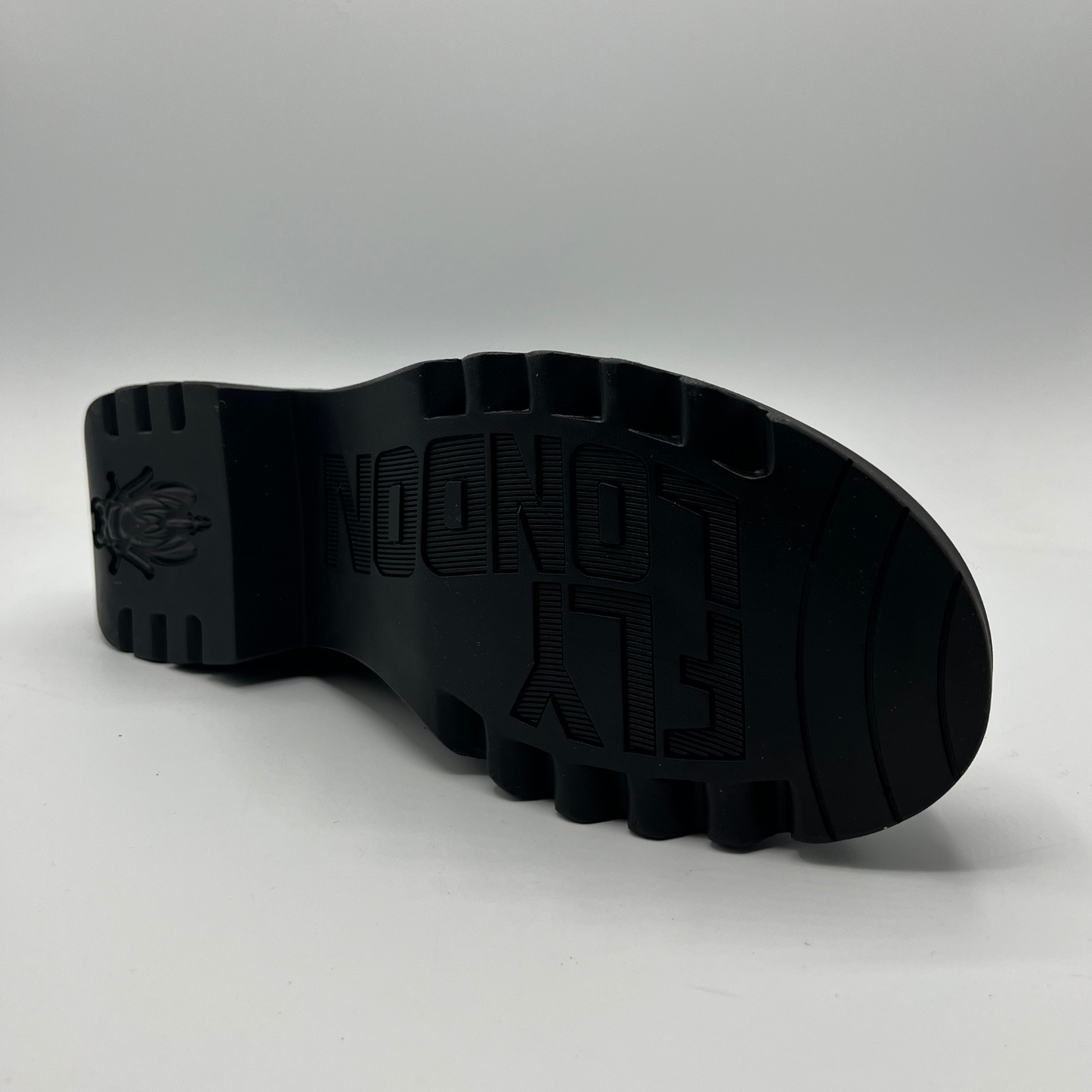 Black sole of a shoe with brand logo on a gray background