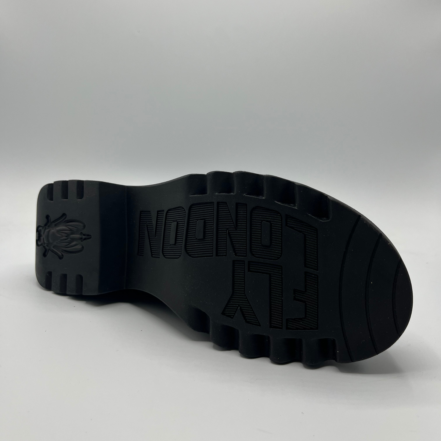 Black sole of a shoe with branding on a gray background