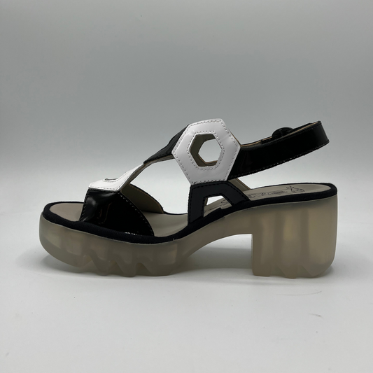 Left facing view of a black and white patent leather sandal with a lug platform sole and adjustable slingback strap.