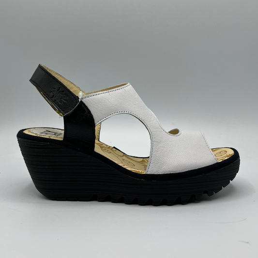 Right facing view of black and white leather strapped sandal with an adjustable velcro ankle strap and comfortable black wedge heel.