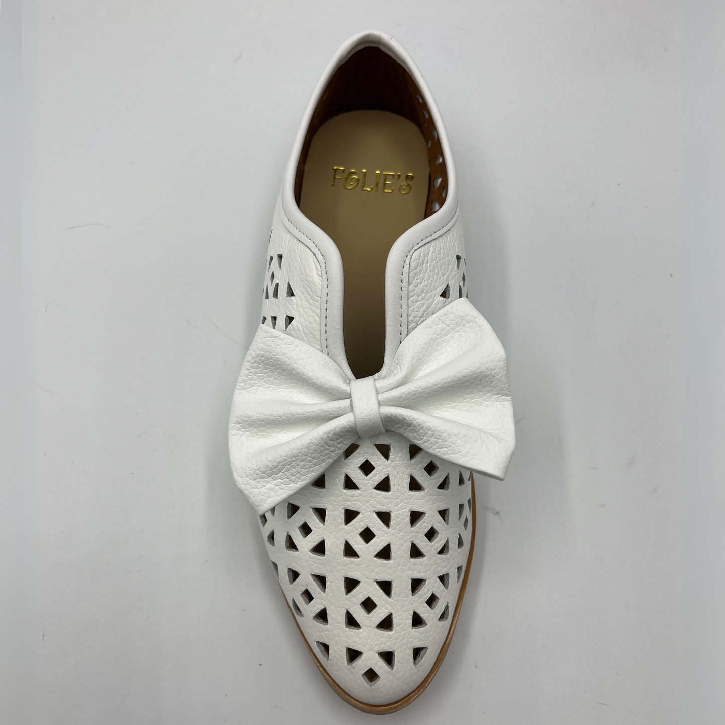Top view of a perforated leather slip on loafer with a low heel and a decorative bow