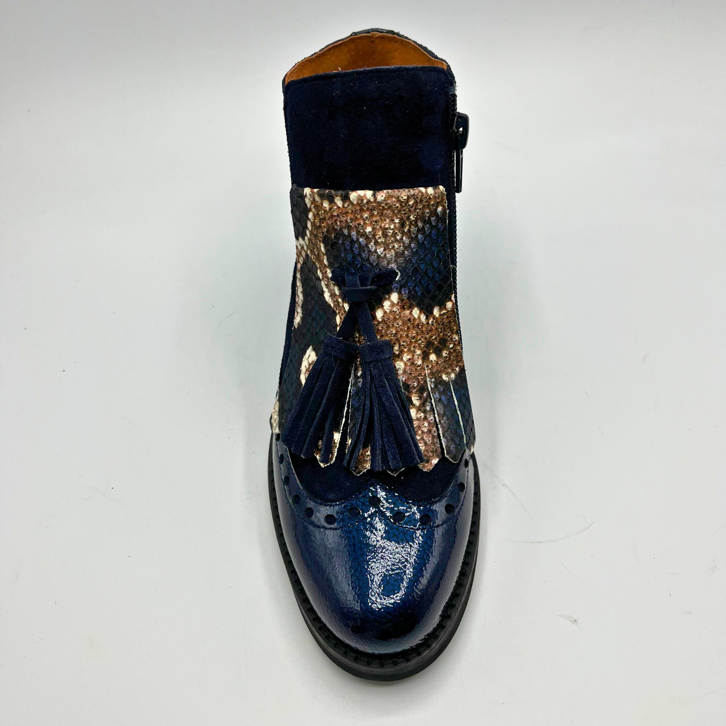 Blue shoe with patterned strap and tassel on a white background