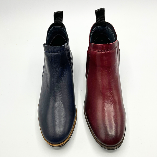 Pair of black and red leather ankle boots on a white background