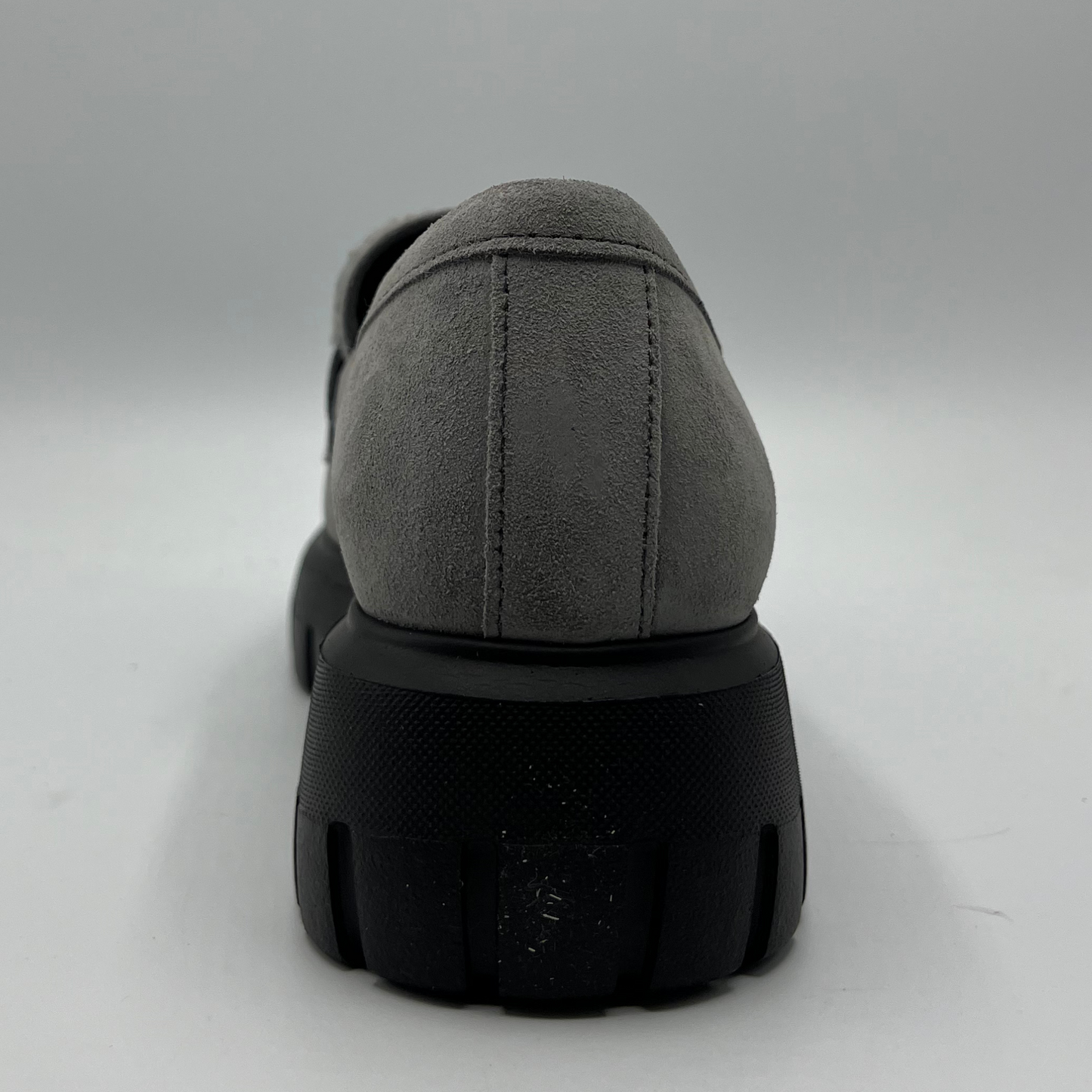 Gray shoe with a black sole on a light gray background