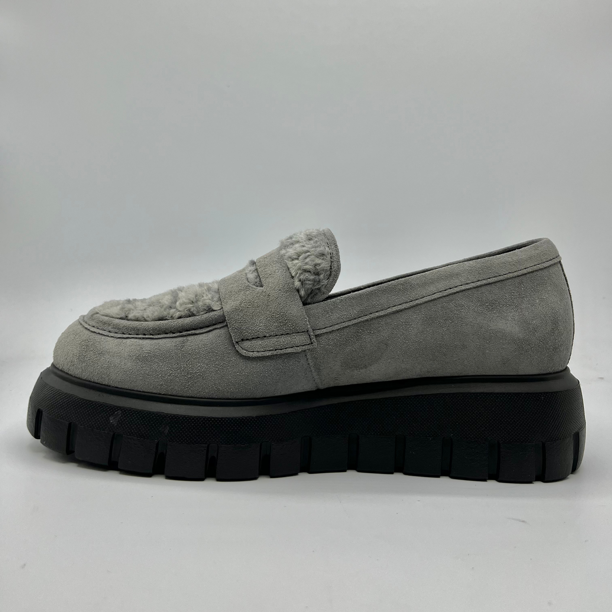 Gray suede loafer with black sole on a white background