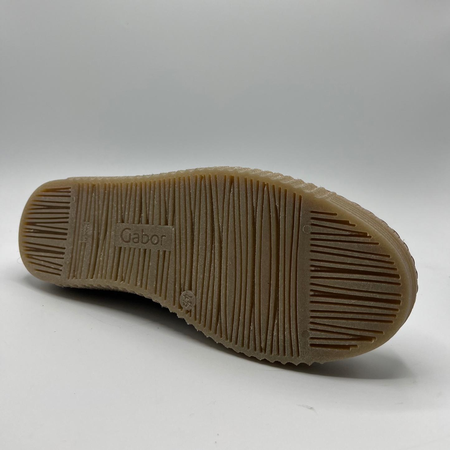 Bottom view of a beige leather shoe with metallic accents and a lace up design