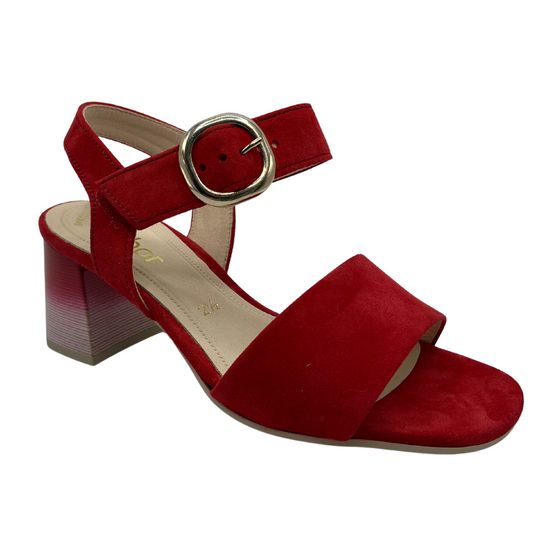 45 degree angled view of red high heeled sandal with soft square toe and silver buckle on the strap