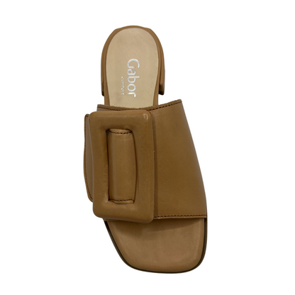 Top view of brown leather slip on sandals with a low wrapped heel and an oversized buckle detail on strap