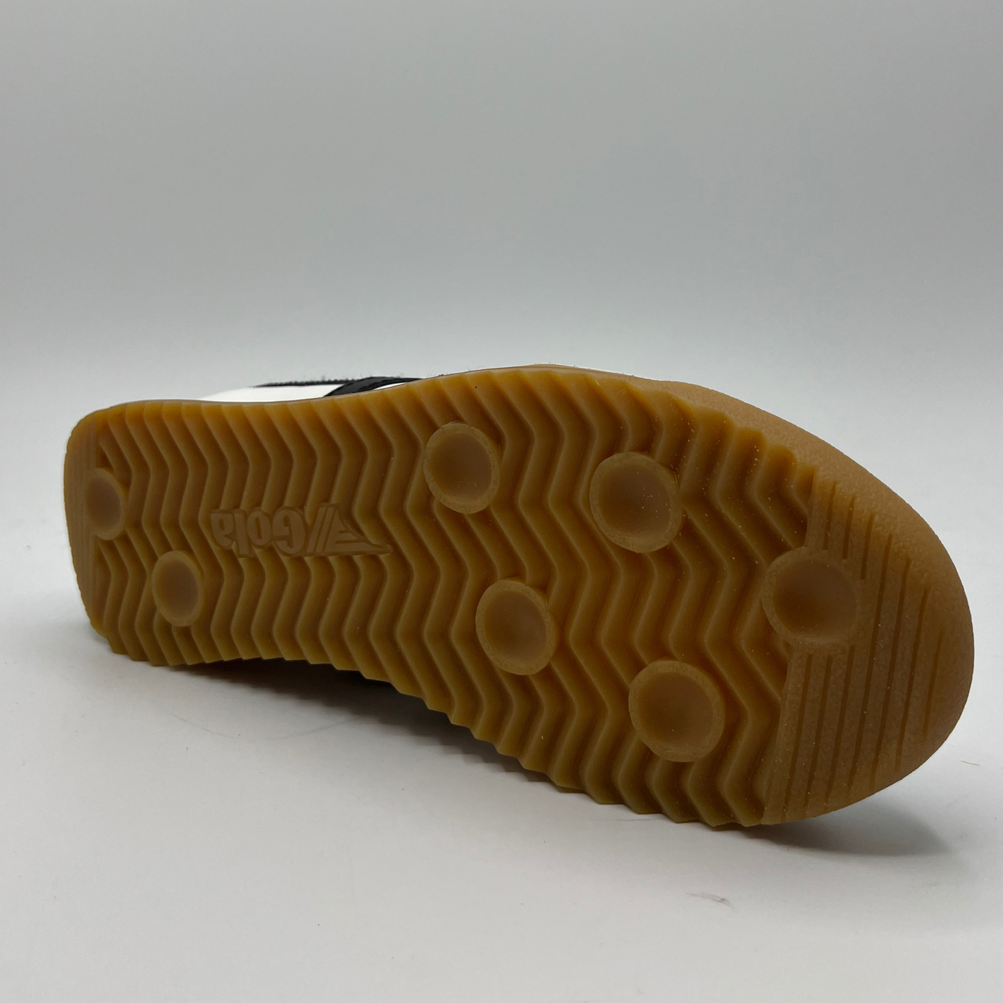 Back view of a leather sneaker with a brown rubber outsole and a lace up design.