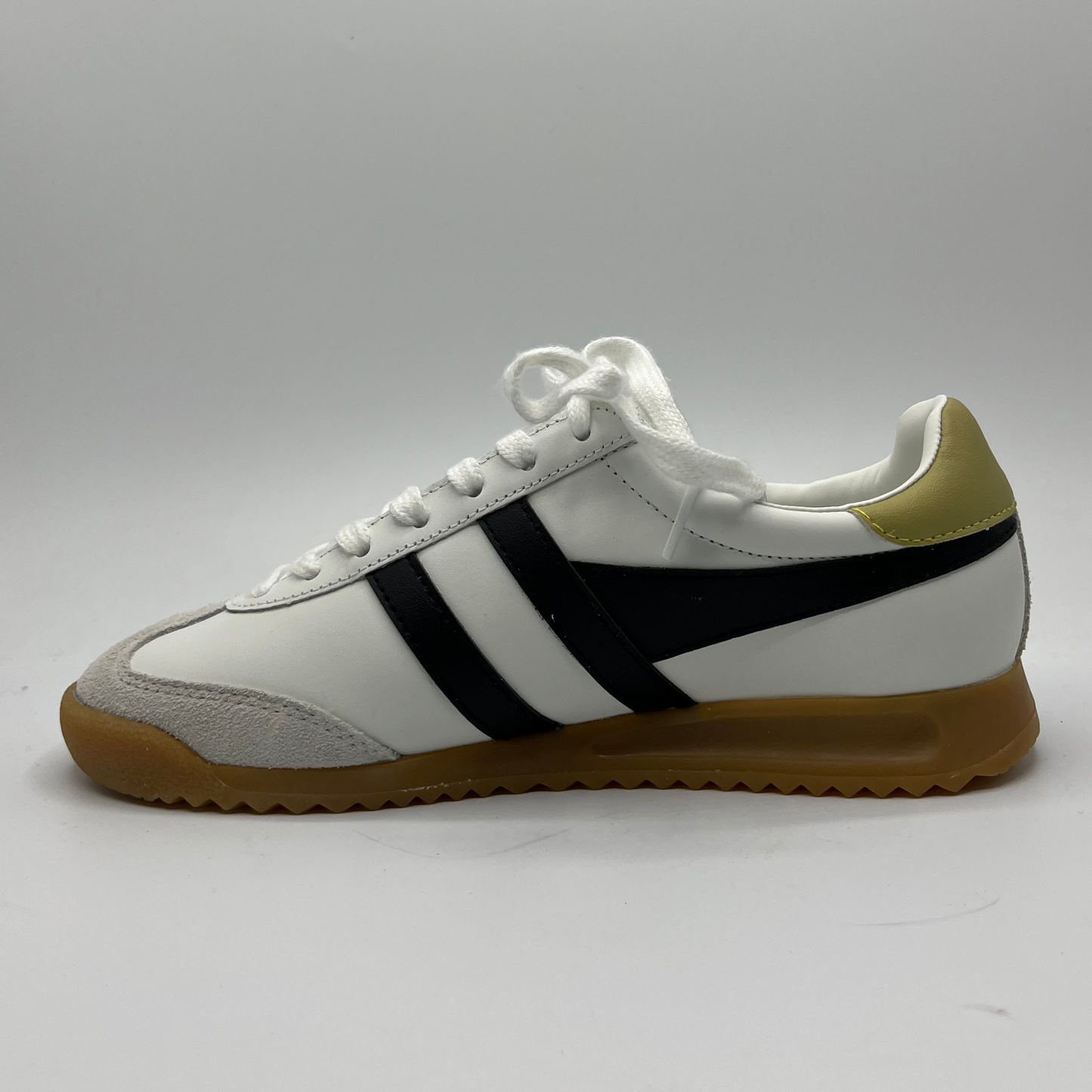 Left facing view of a leather sneaker with a brown rubber outsole and a lace up design.