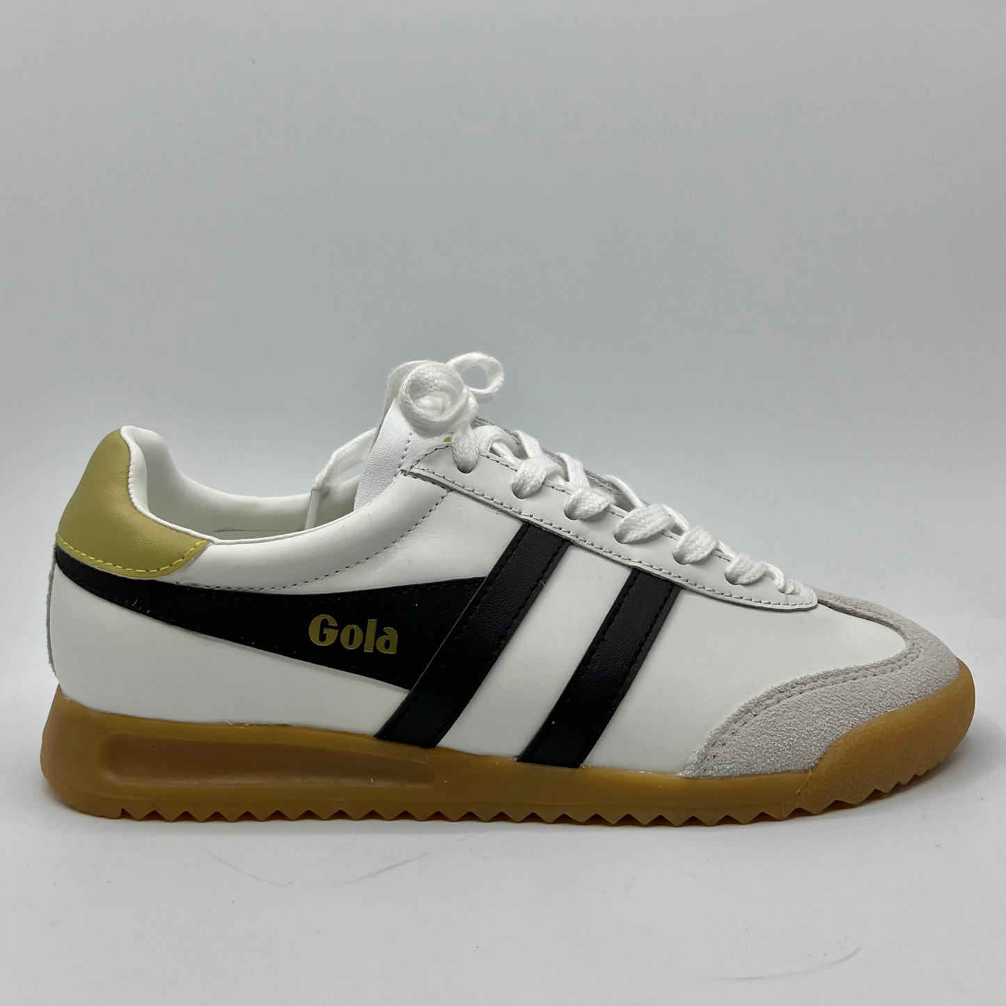 Right facing view of a leather sneaker with a brown rubber outsole and a lace up design.