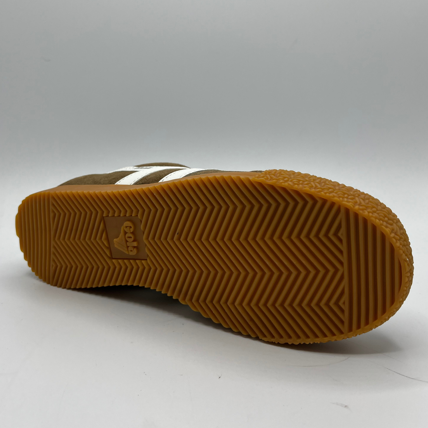 Brown sneaker sole with white stripes and textured pattern on a gray background