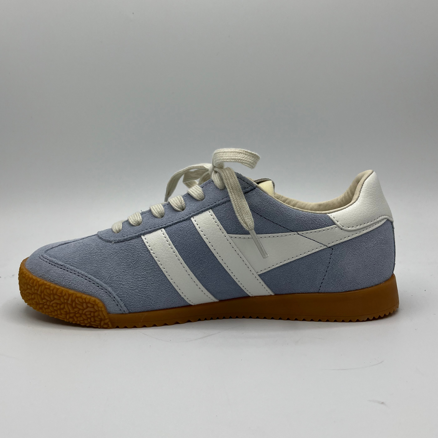 Left facing view of a blue suede sneaker with white accents, a gum outsole and a lace up design.