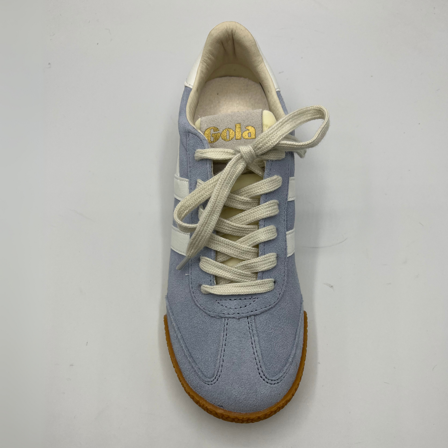 Top view of a blue suede sneaker with white accents, a gum outsole and a lace up design.