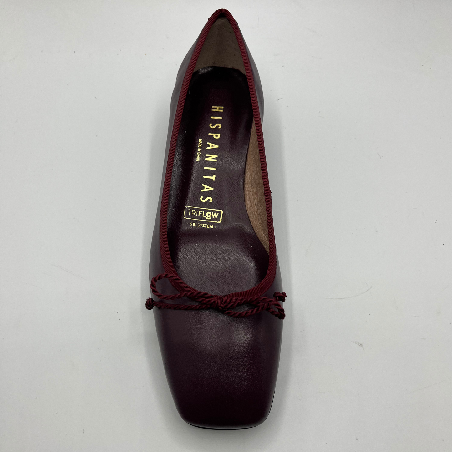Maroon shoe with brand name on a white background