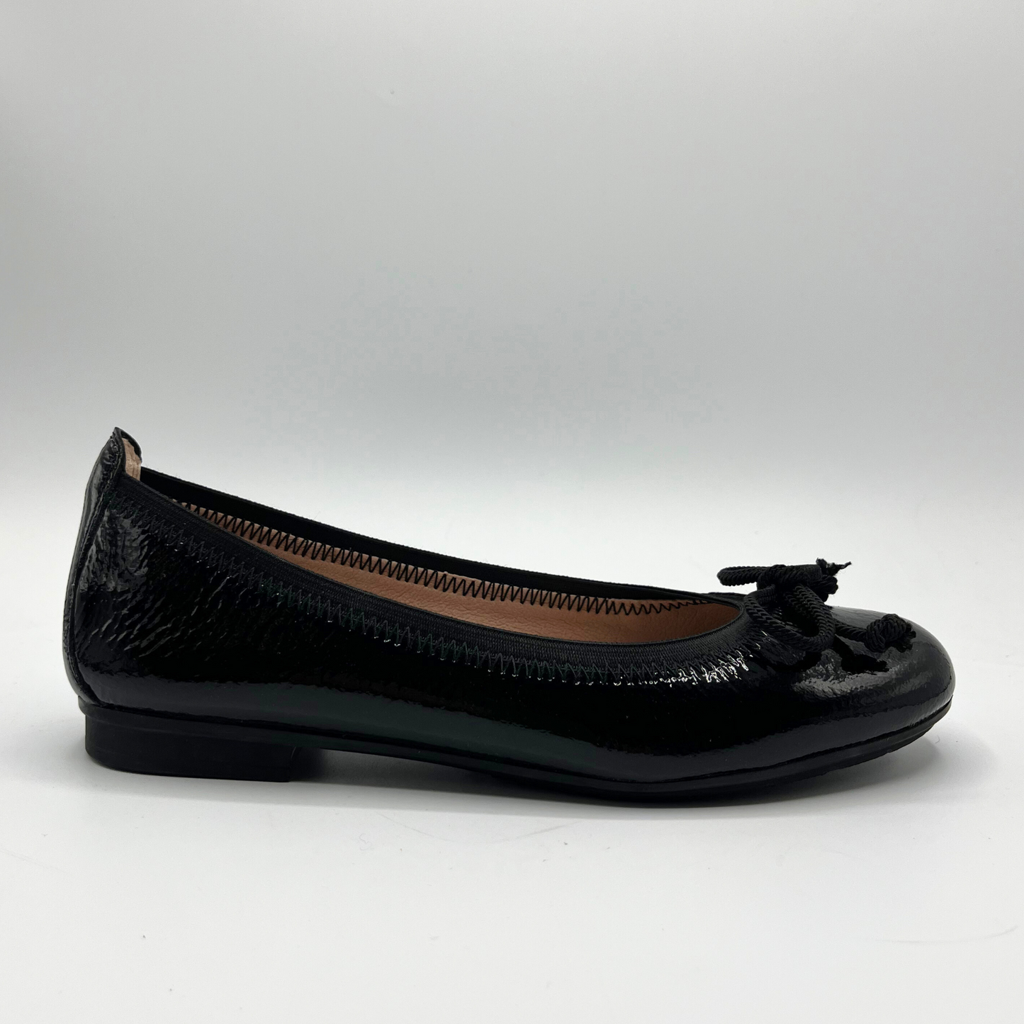 Black flat shoe with a bow on a white background