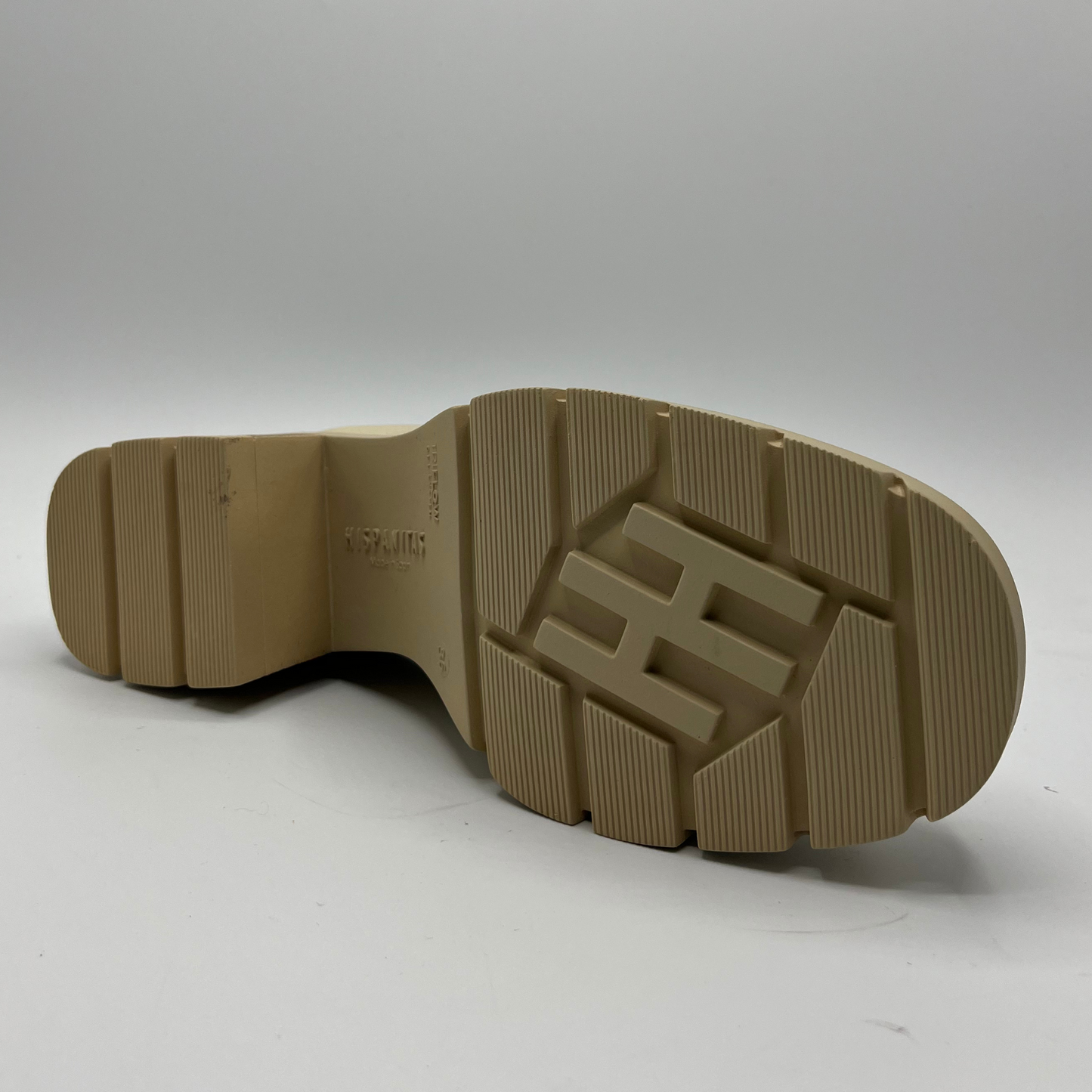 Brown sole of a shoe with a visible brand logo on a white background