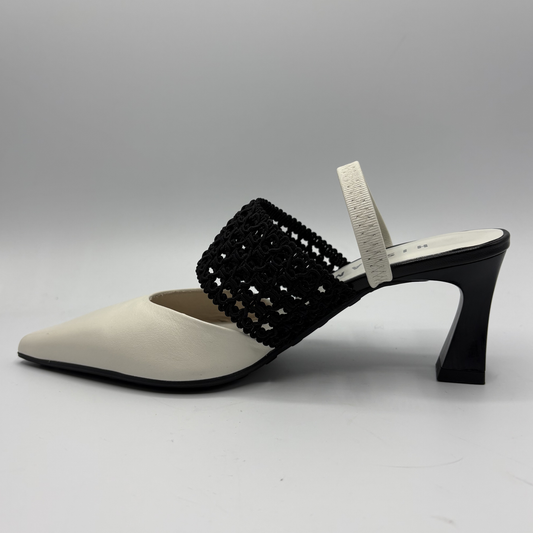 White shoe with black woven strap on a gray background