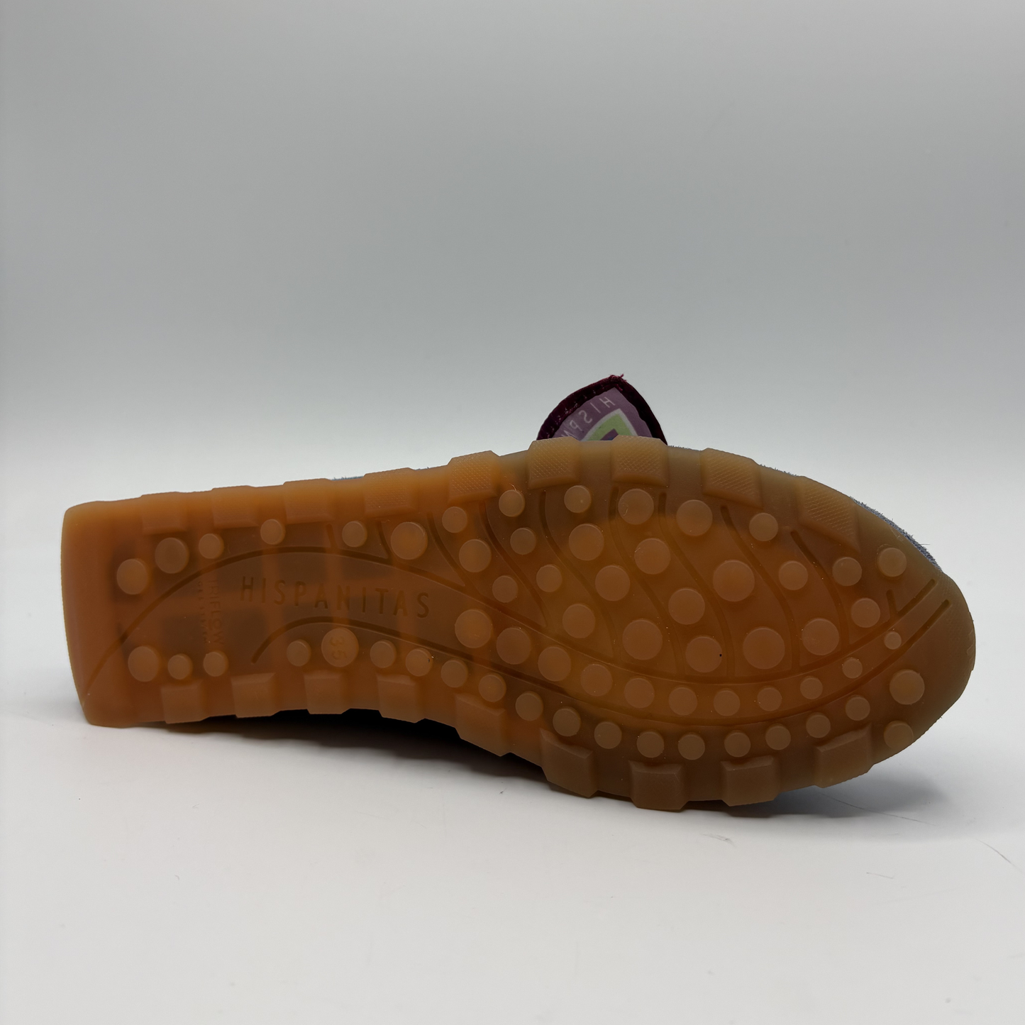 Bottom view of a blue suede loafer with a scarf accent