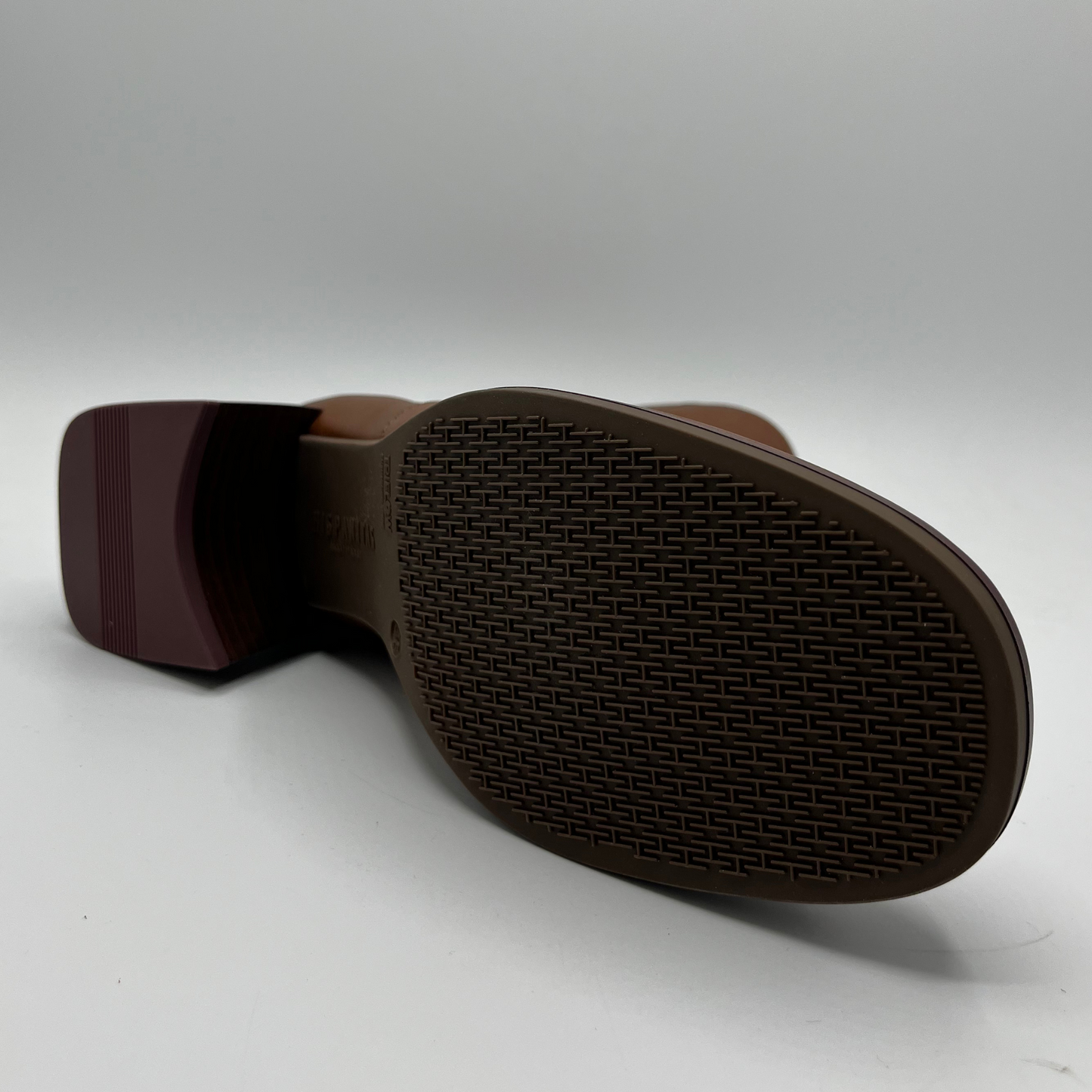 Brown shoe sole with tread pattern on a white background