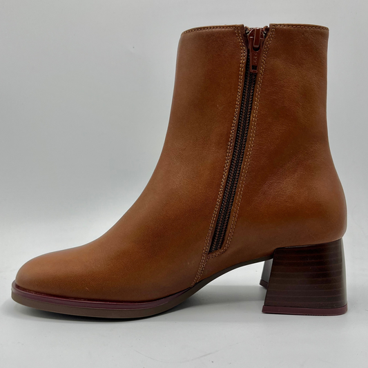 Brown ankle boot with a block heel on a light gray background