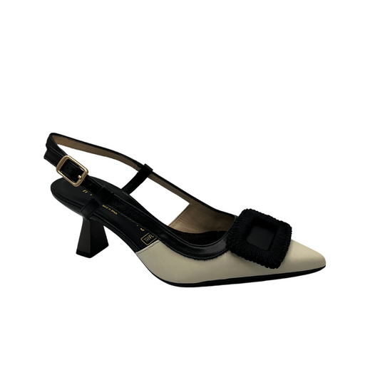 Angled view of black and ivory leather pump with flared heel and slingback strap.