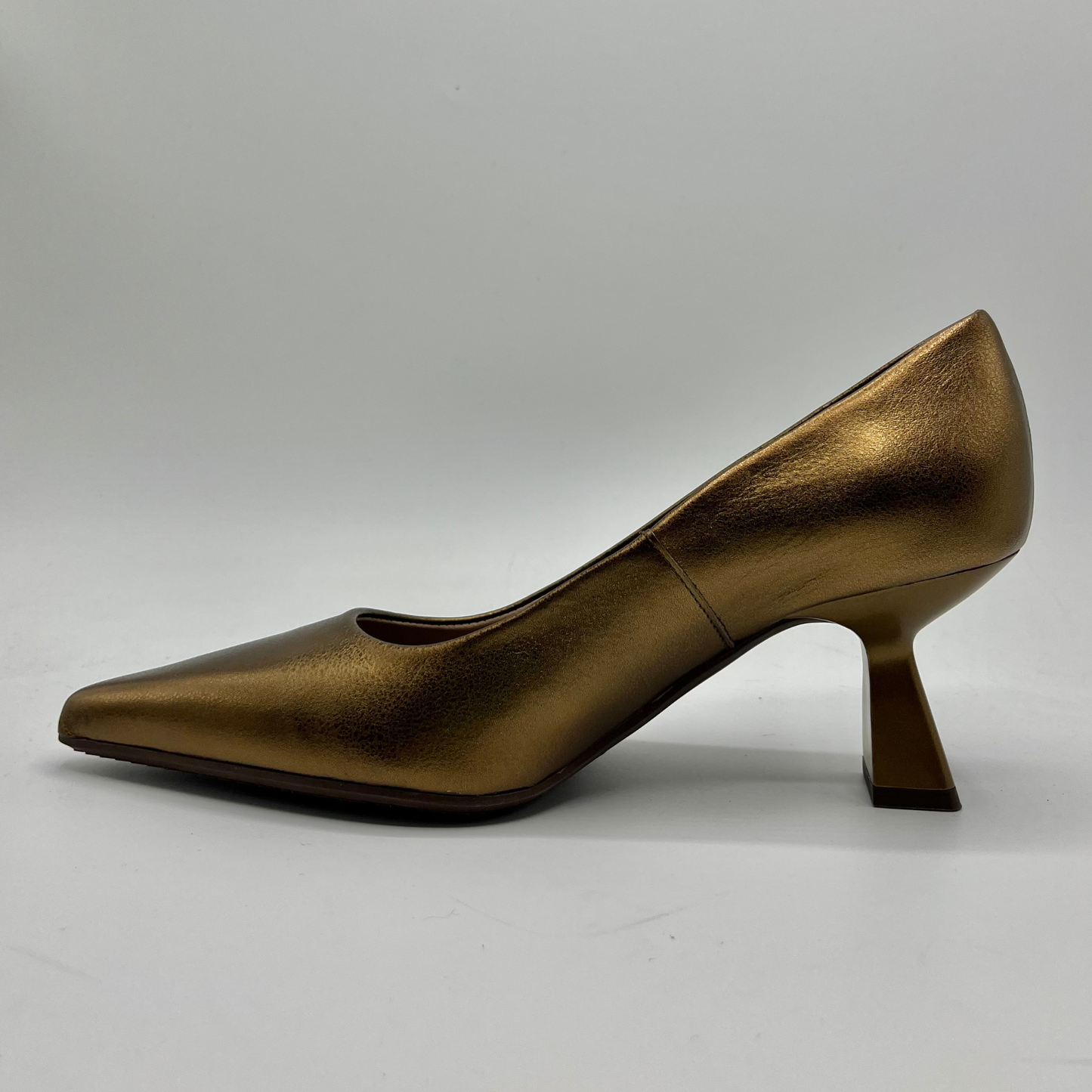 Bronze high-heeled shoe on a gray background