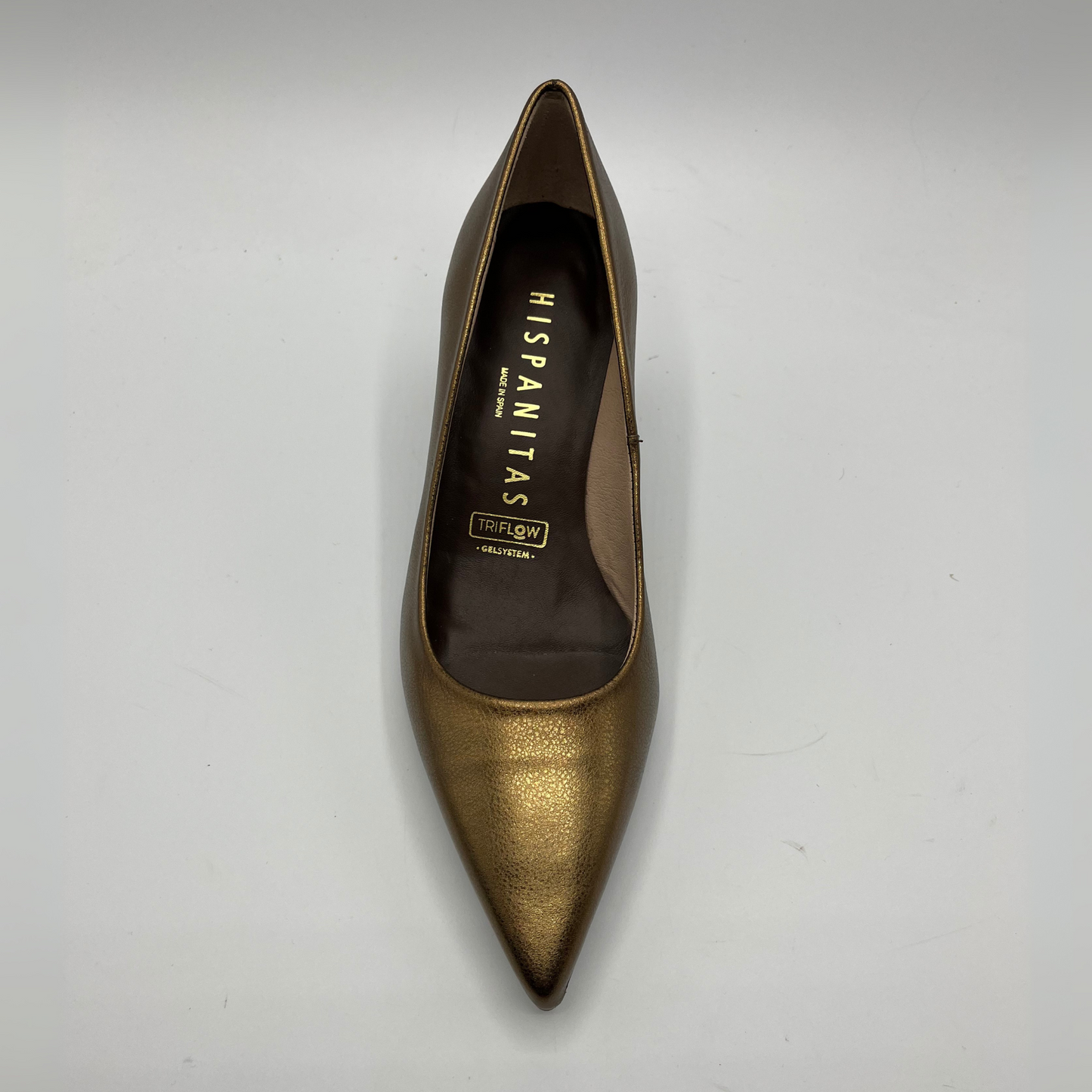 Gold high-heeled shoe with 'Hispanitas' branding on a white background